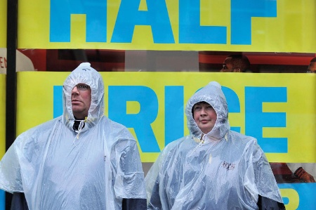 Man and woman standing outside wearing raincoats