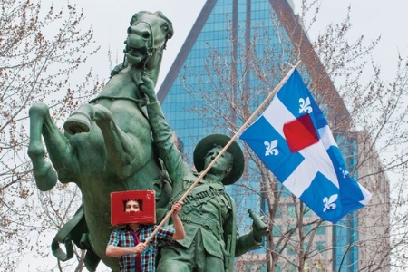 Student holding a flag and standing on a statue