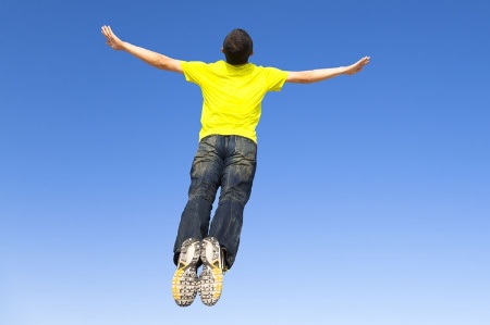 Flying man against blue sky