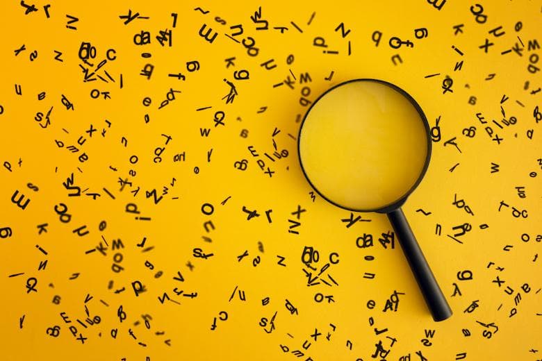 A magnifying glass among scattered letters represents problem solving