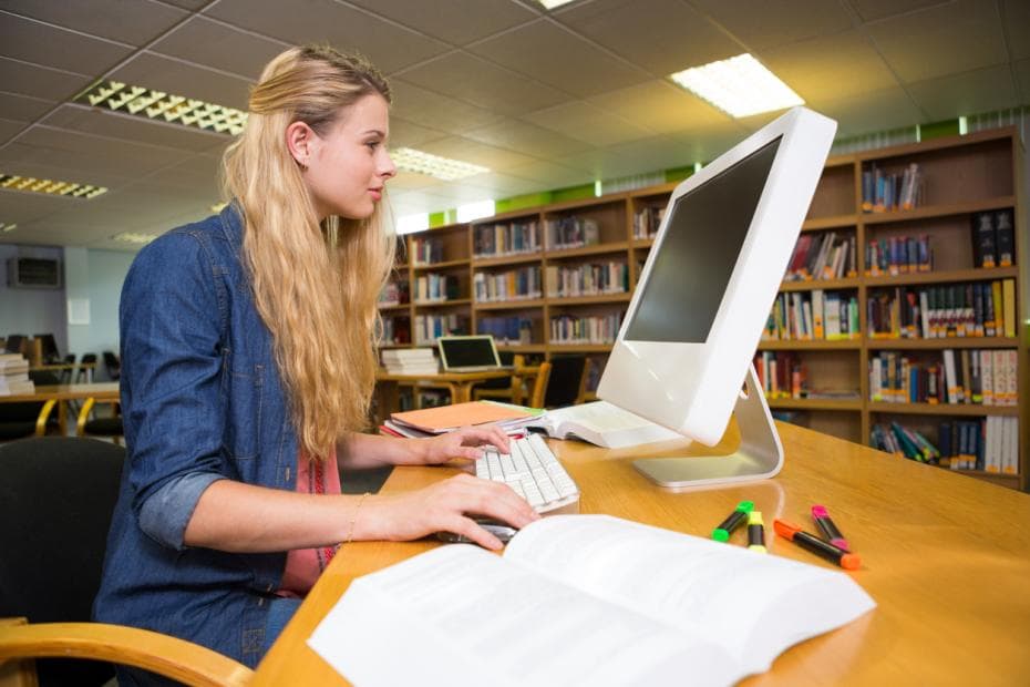 A female student browsing a computer in the library