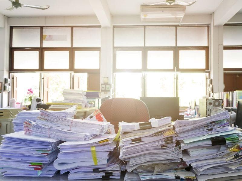 Image of a desk piled with papers