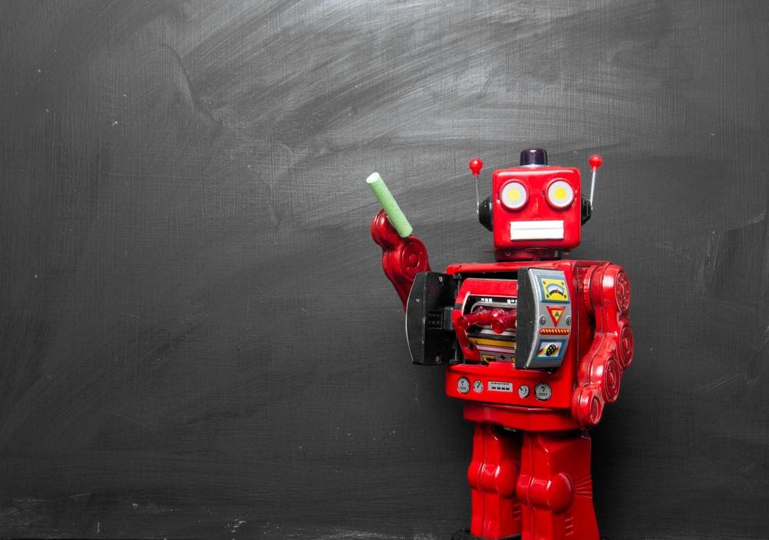 Robot standing in front of a chalk board
