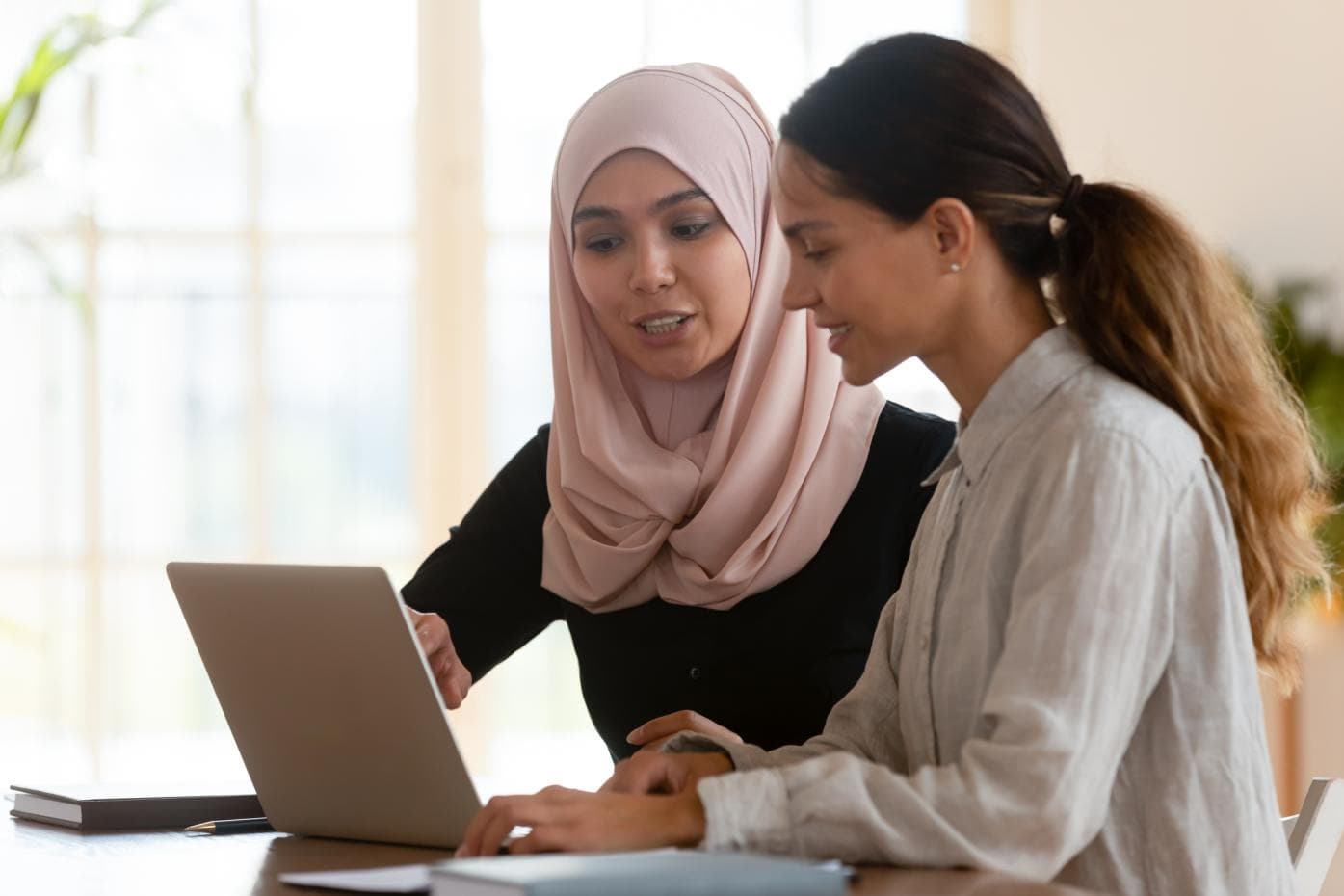 Two young women at a laptop having a conversation