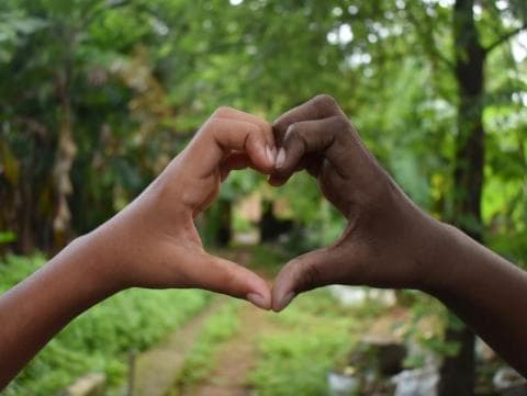 Image of people of different ethnicities joining hands in a heart shape