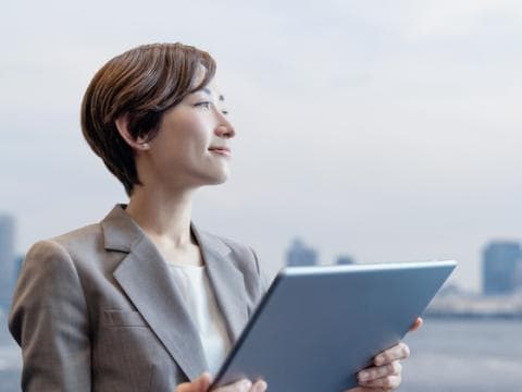 Asian woman holding laptop illustrating leadership