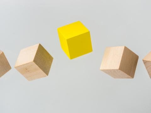 Blocks in the air with a yellow one in the middle