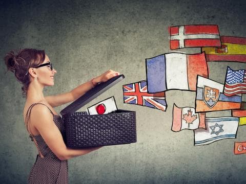 Woman holding a box out of which a selection of national flags are flying