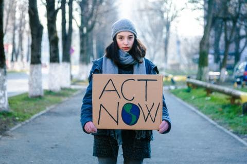Young climate activist with a sign
