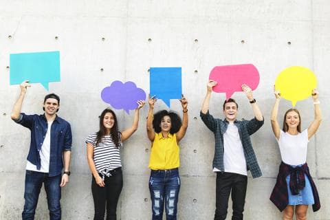 Group of young adults holding up speech balloons