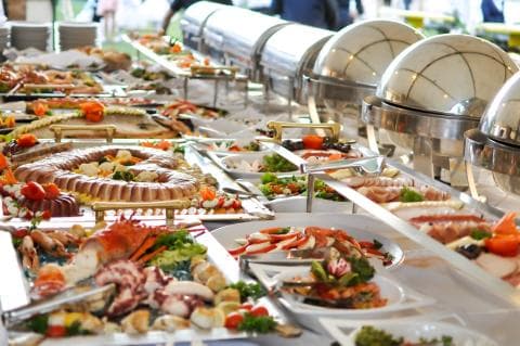 A buffet table, groaning with food, stretches nearly as far as the eye can see