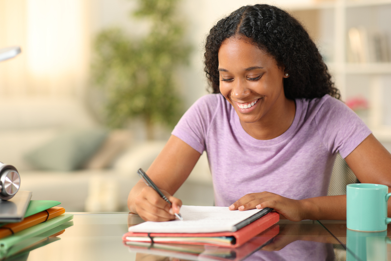 Smiling student, writing motivational letter