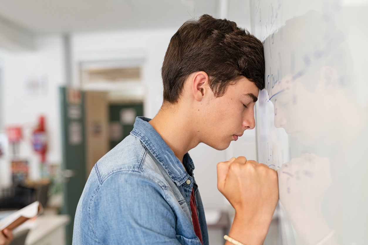 Student with head against wall in frustration