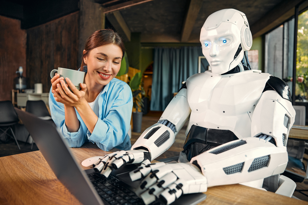 Woman drinks cup of tea while robot does her work