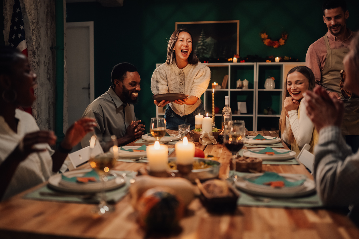 A group of friends laughing around the dinner table