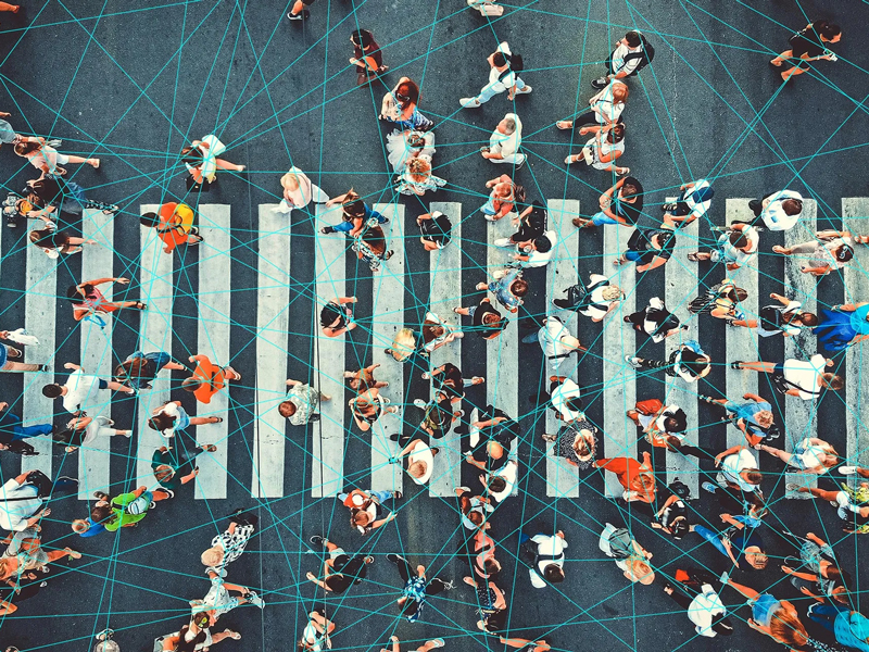 Many people walking over a pedestrian crossing