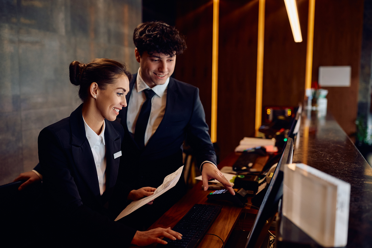 Two hotel workers at the hotel reception desk