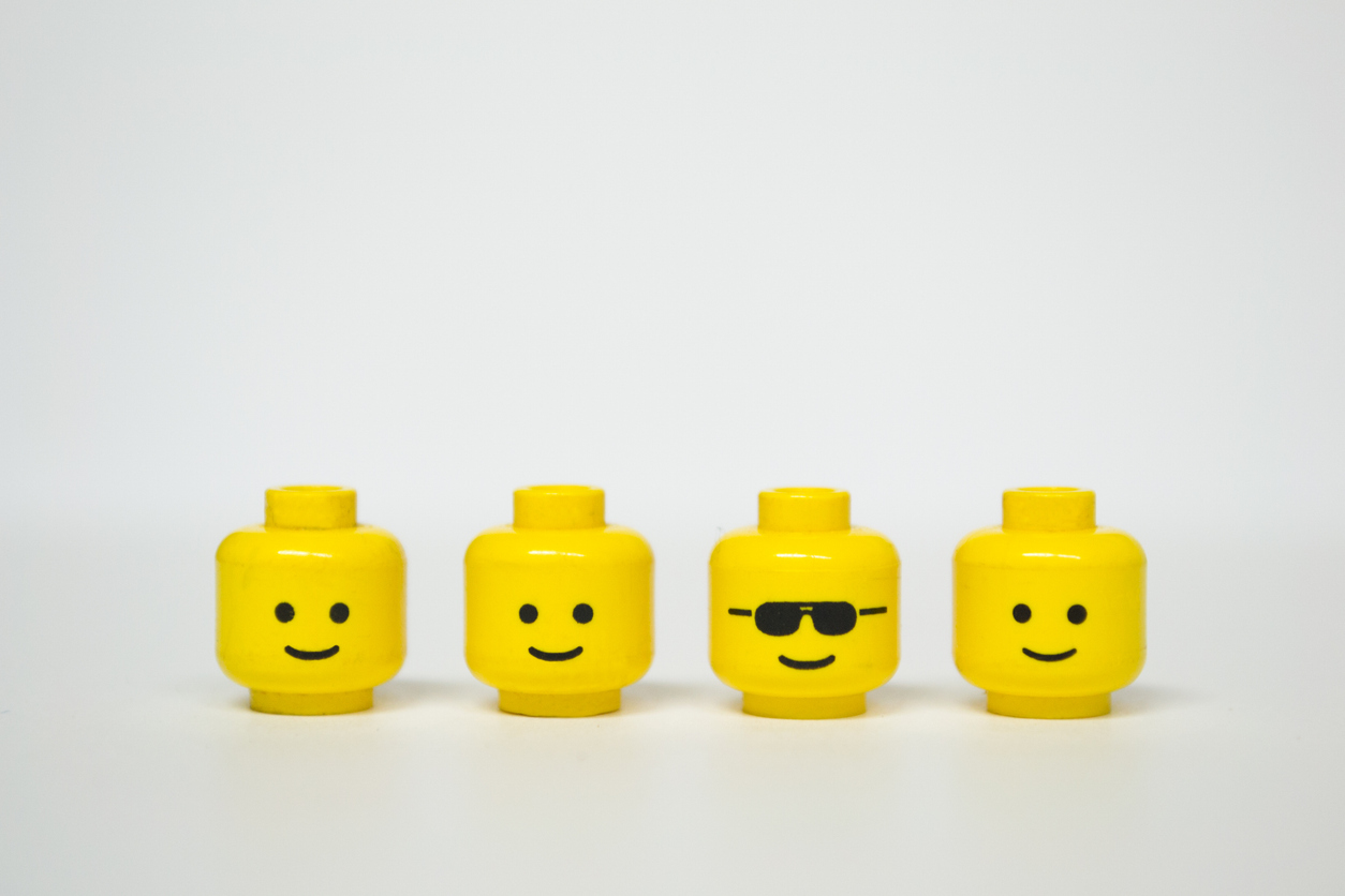 Four Lego heads, one wearing shades