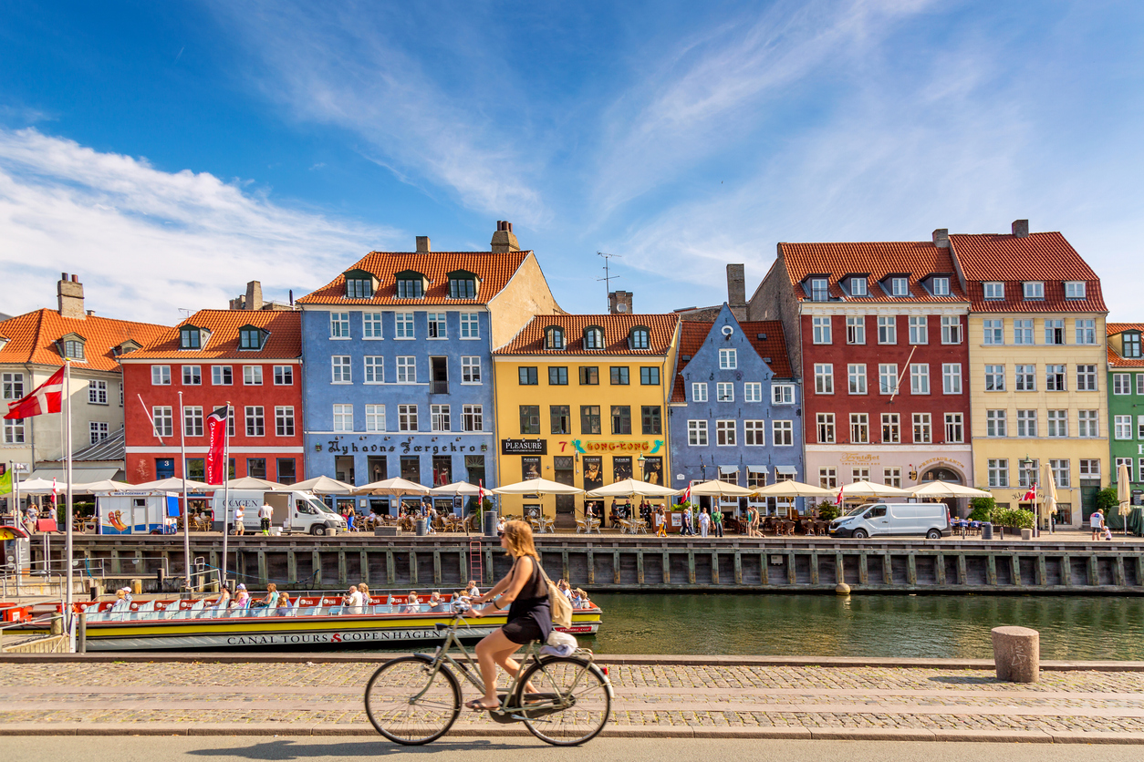 Colourful houses in Copenhagen, with woman cycling past