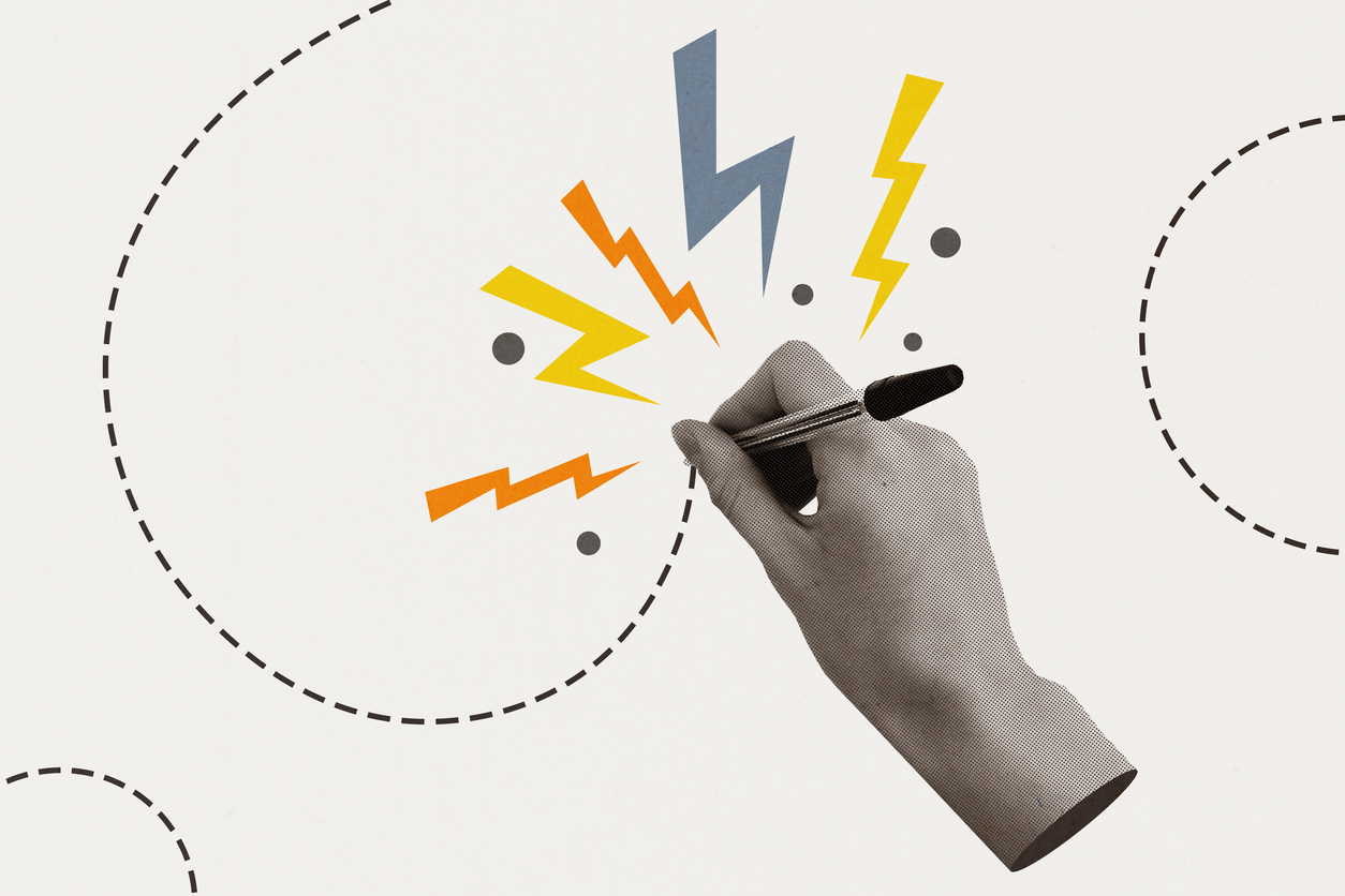 Disembodied hand writing with a biro, with lightning sparks emerging from the page