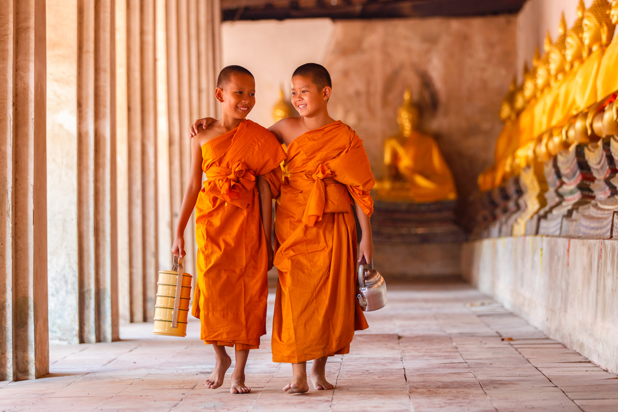 Two young Buddhist monks, walking through a monastery in Cambodia