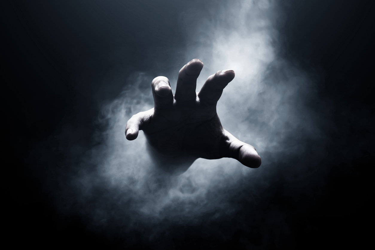 Hand emerging from darkness