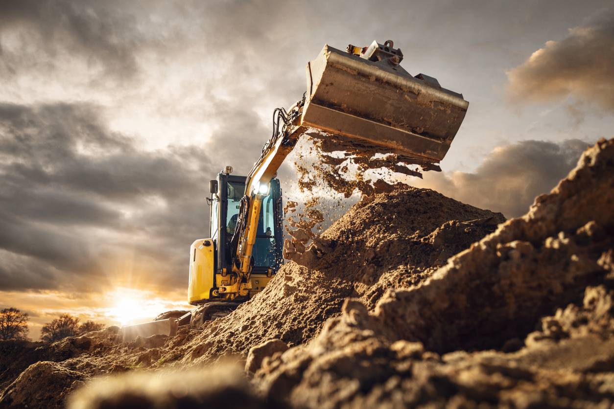 Digger at work, with sun setting in the background