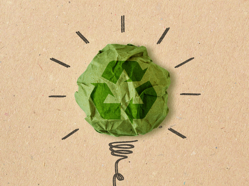 Light bulb drawing with recycling sign on crumpled recycled paper