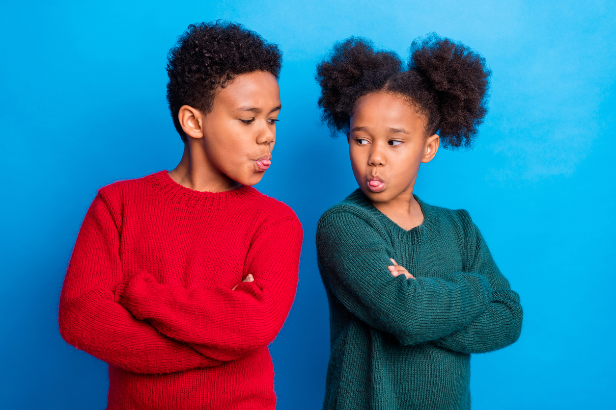 Two children, sticking tongues out at one another