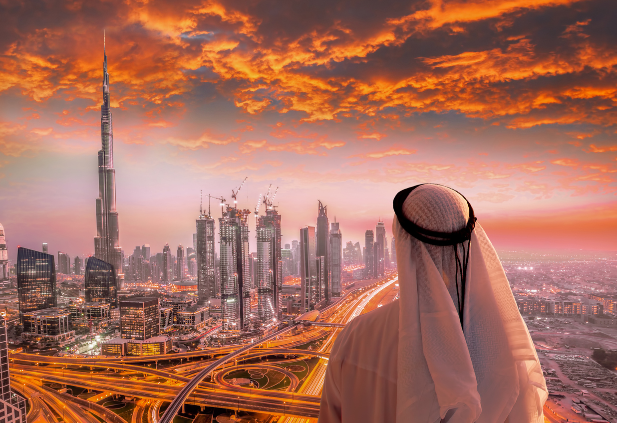 Arab man looks out over dramatic Dubai cityscape