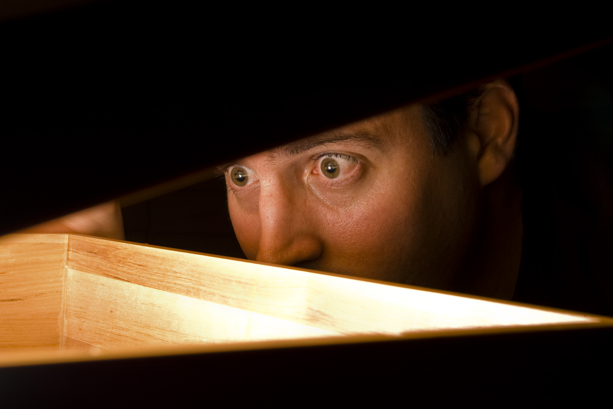 Man looking into box with expression of shock