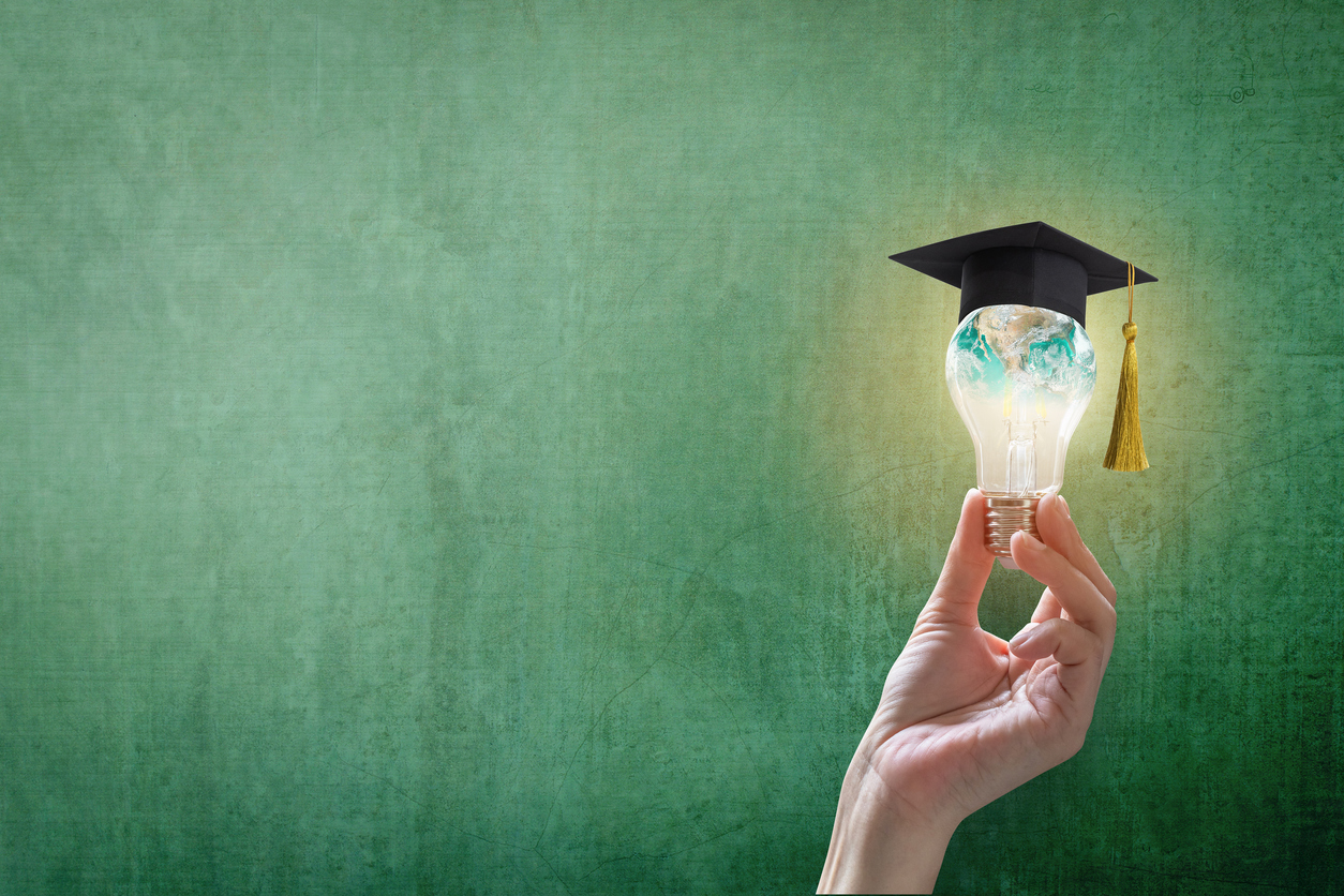Lightbulb wearing a mortarboard and painted with an image of the world