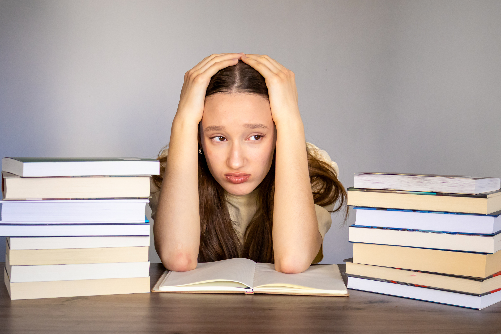 Student, surrounded by books and brochures, looking stressed
