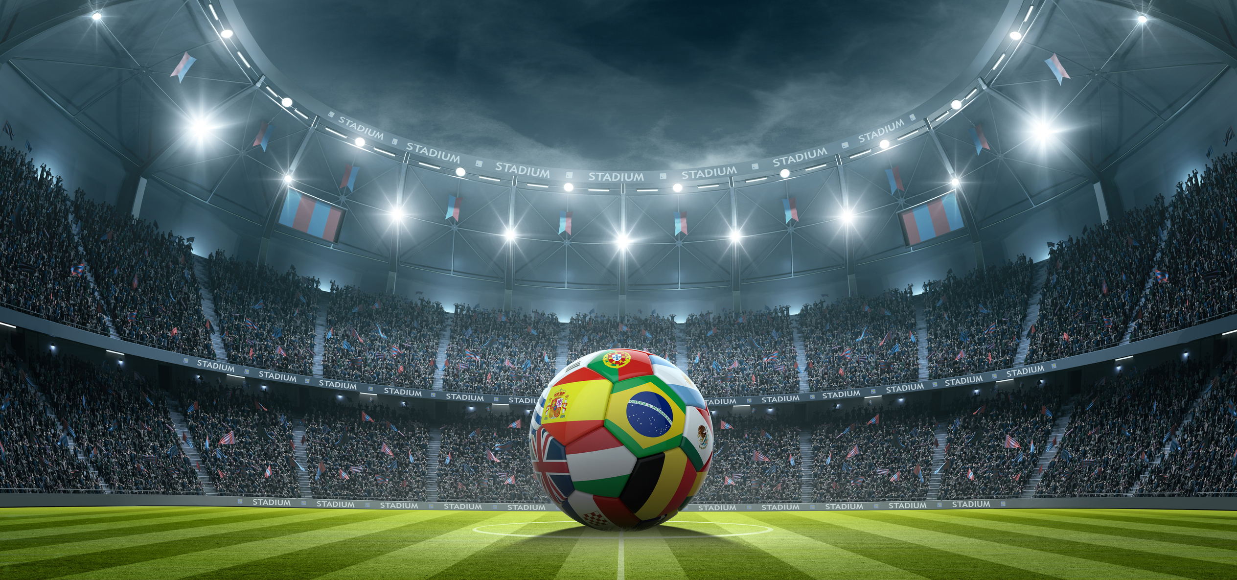 Football painted with different countries' flags, in the centre of a football stadium