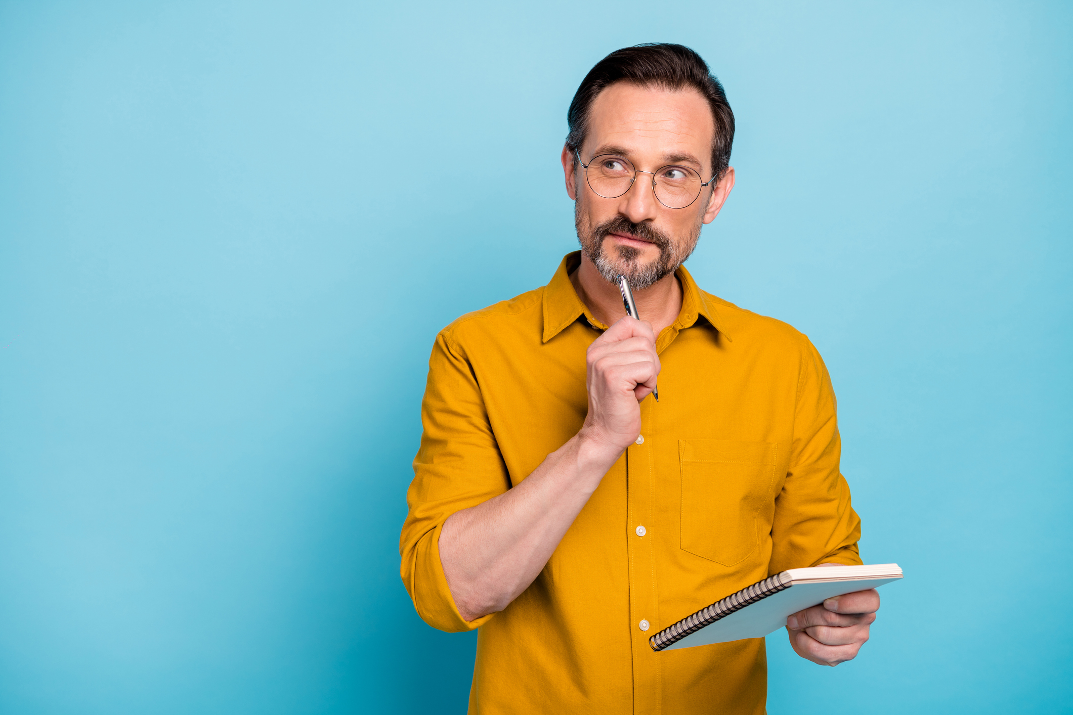Man with notepad and pen, thinking