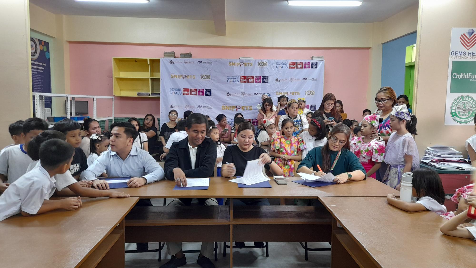 Bagong Barangay Elementary School Principal Maria Bernadeth Pablo signs the Memorandum of Understanding with Mapúa administrators in Pandacan, Manila