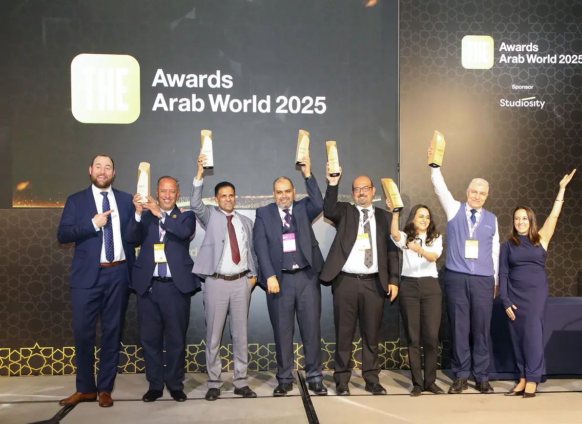 Award winners holding trophies on stage at THE Awards Arab World 2025, sponsored by Studiosity