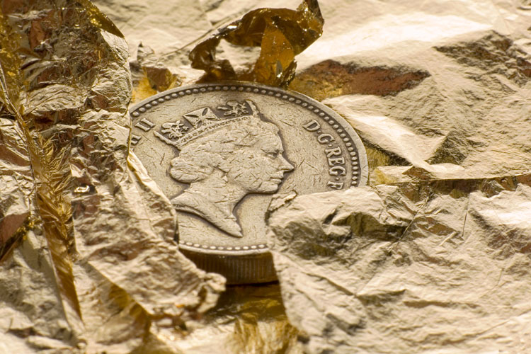 British pound coin on gold leaf