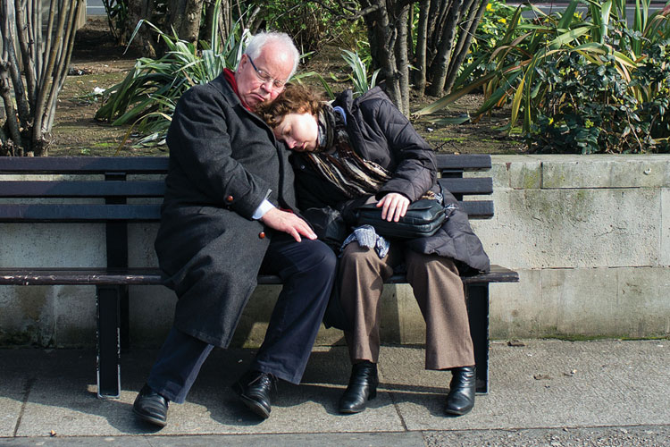 Couple sleeping on bench in London