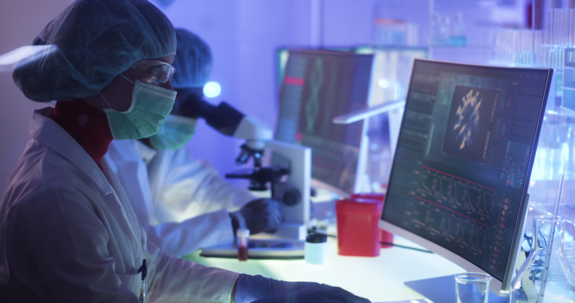 Scientists in protective suits look at Covid images online