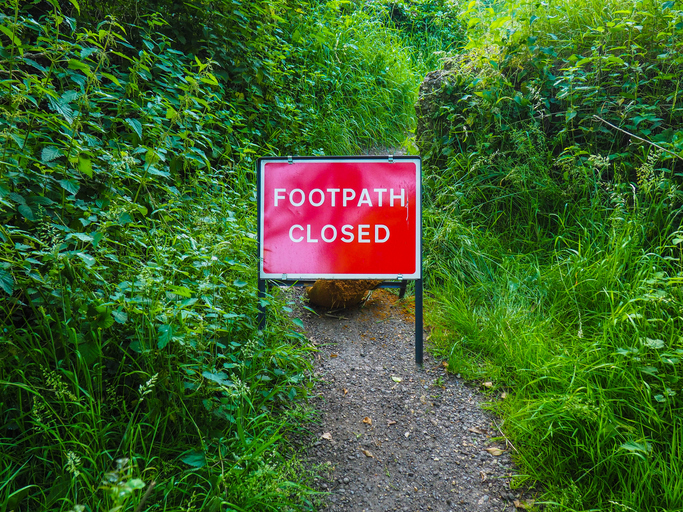 A footpath with a sign saying it is closed, illustrating restrictions on free speech