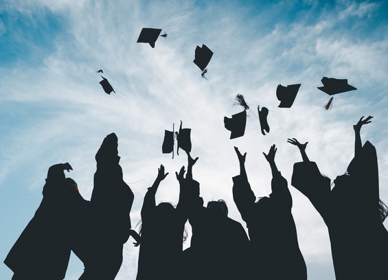 Graduates throw their caps into the air, symbolising the graduate premium