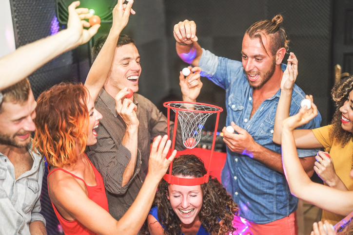 Students play a drinking game. Pushing the uni experience could backfire on the university sector as students push for fee refunds