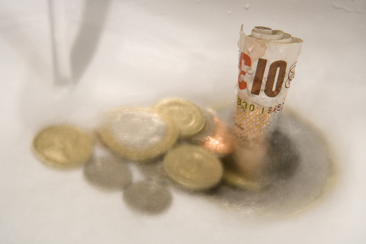 Money washing down the drain, symbolising the diminishing graduate premium