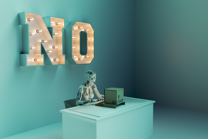 A robot working on a computer with "no" in big letters on the wall, illustrating the rejection of AI