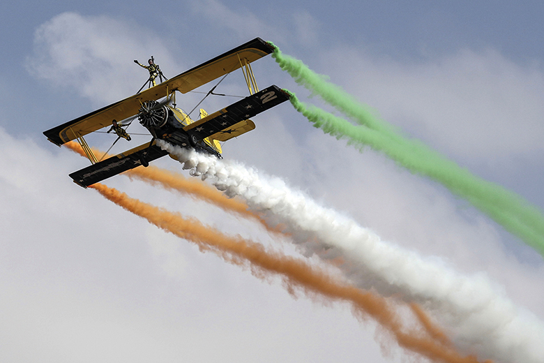Biplane trailing coloured smoke