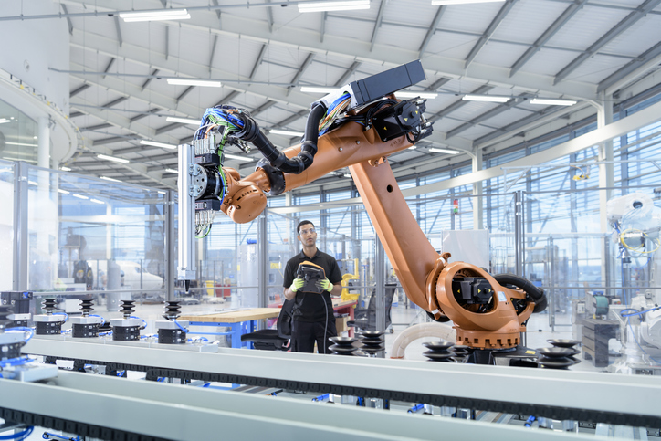 An engineer programmes a robot in a robotics research facility, illustrating regional growth
