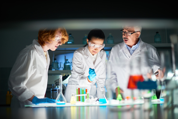 Scientists with liquids of various colours in test tubes, symbolising policy options