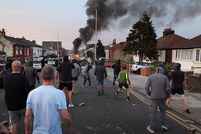 Protesters throw stones at police after disorder broke out on July 30, 2024 in Southport, England. Rumours about the identity of the 17-year-old suspect in yesterday's deadly stabbing attack here have sparked a violent protest.