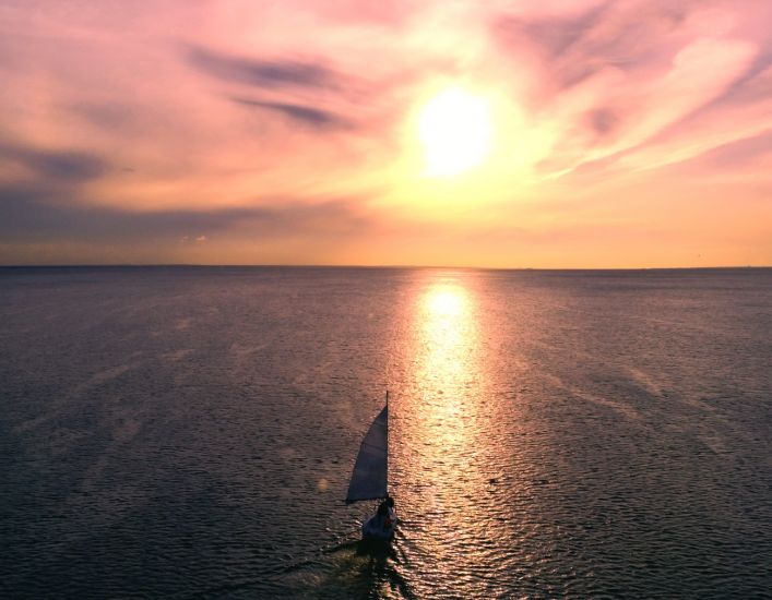 A yacht sailing into the sunset, illustrating retirement